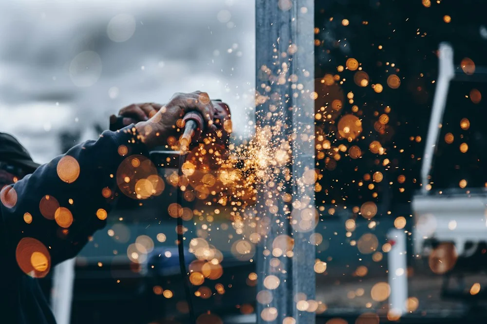 Fotografía de referencia: trabajo de corte y acabado de metal en un taller industrial