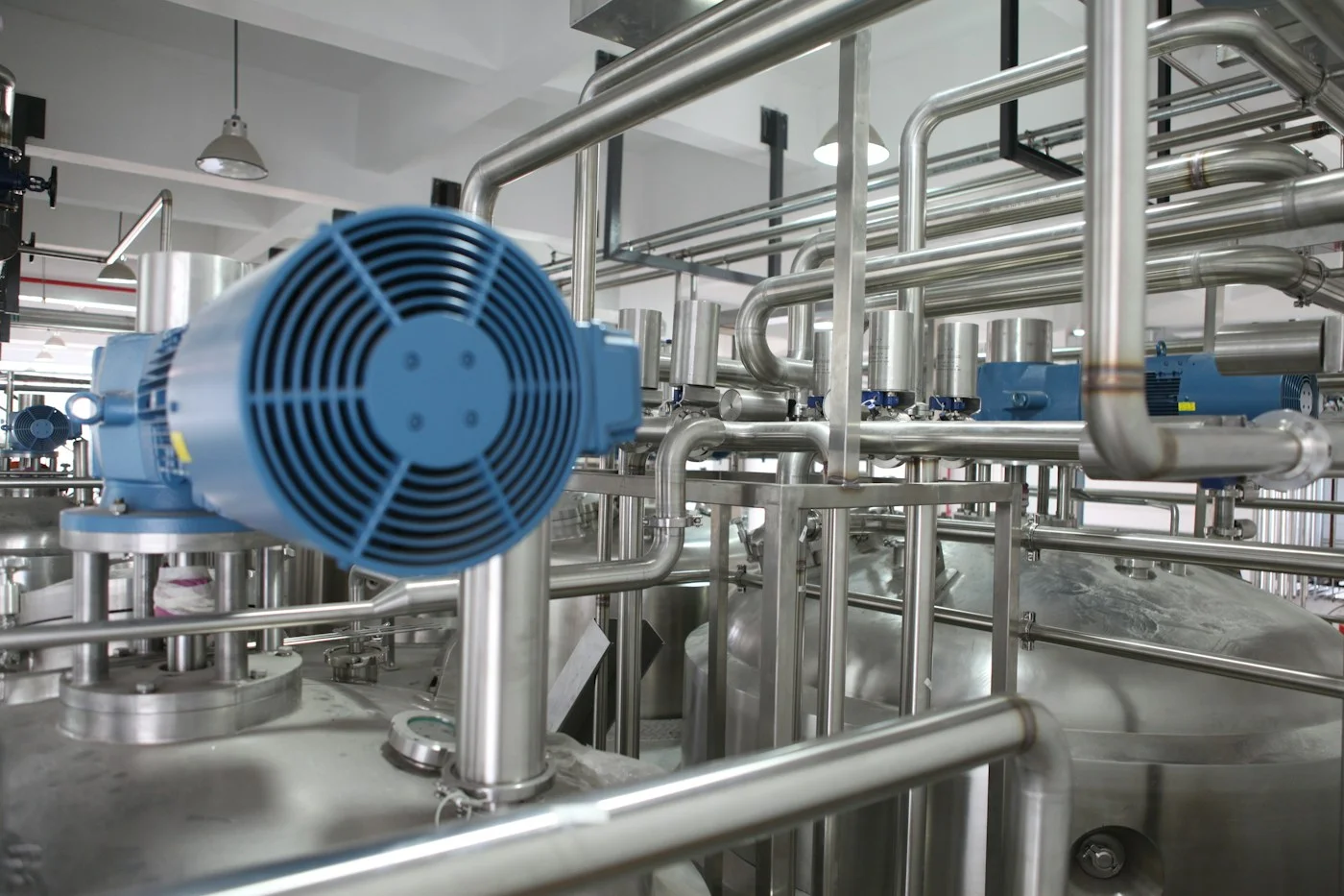 Fotografía de referencia: tubería de acero inoxidable y equipo de proceso en planta industrial